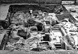 Halifax Place, Nottingham: excavations from 1978 to 1980 revealed a dense concentration of medieval and later structural remains, including post-hole settings interpreted as the foundations of Pre-Conquest bow-sided buildings and a host of medieval to modern caves, pits, wells and building foundations. The photograph shows Gordon Young triangulating the northern edge of a pre-Conquest boundary ditch running from east to west. ©Nottingham City Museums and Galleries.